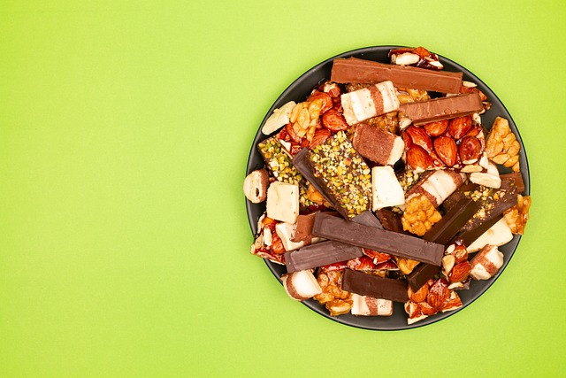 Artisan dark chocolate bar with visible cocoa nibs and sea salt flakes partially unwrapped from kraft paper packaging on a slate surface with cacao beans