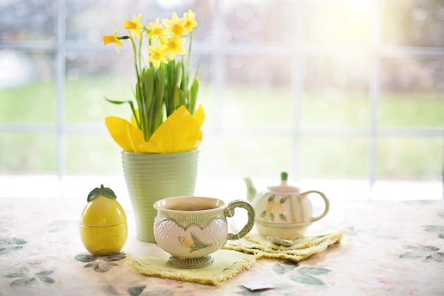 Warm photograph of a family kitchen table set with artisan bread, olive oil in a ceramic pourer, fresh herbs, aged cheese, and colourful seasonal vegetables, bathed in soft natural window light